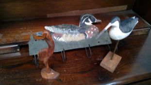 Tin coat hooks modeled as a duck, wood carved stork and a painted wood model of a wading bird.