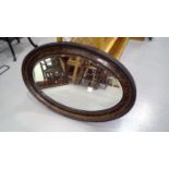 Oval framed wall hanging mirror with a beveled edge. Height 54.5cm width 81.5cm
