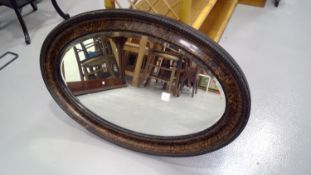 Oval framed wall hanging mirror with a beveled edge. Height 54.5cm width 81.5cm