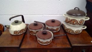 Vintage enamel saucepans, casserole pots, and a stovetop kettle.