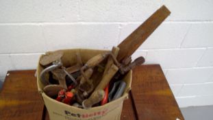A box of tools that includes saws, hand-crank drills, etc.