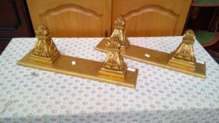 A pair of gold painted wooden wall mounted shelves