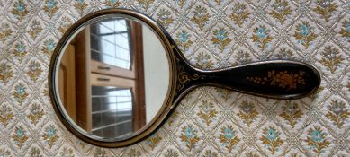 An early 20th century black lacquer oriental handheld vanity mirror.