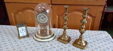 A French style brass carriage clock, two brass candlesticks and another timepiece.