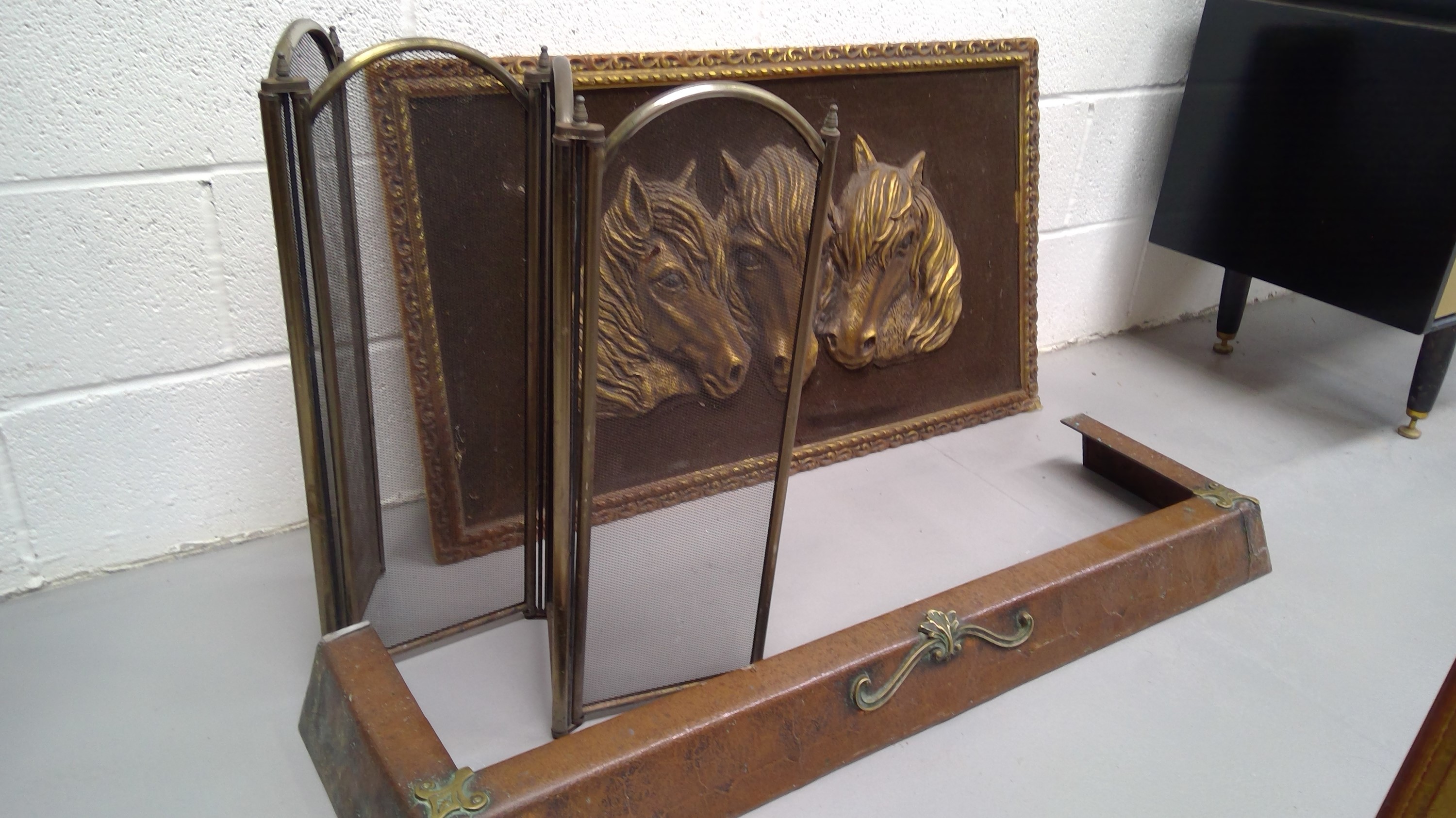 Copper and brass Art Nouveau style fender, brass fire screen, and a relief image of horses.