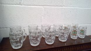 A box containing a collection of glass tankards including three with lids, and other items.