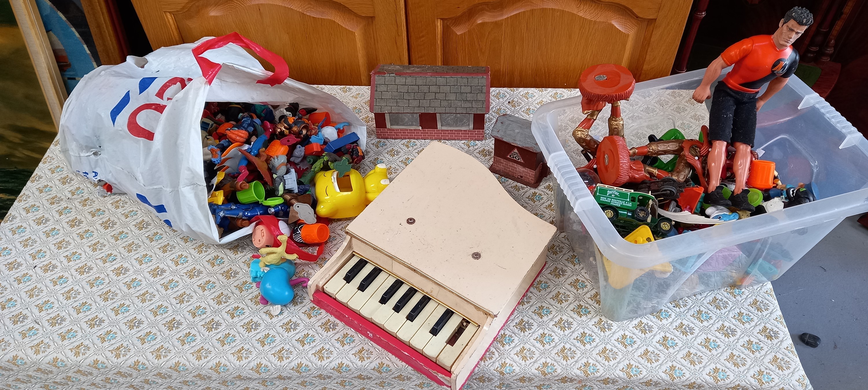 A vintage toy piano, model railway buildings and other toys.