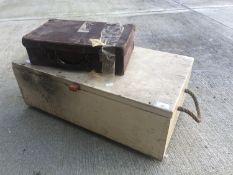 Pine box with rope handles and a small leather suitcase.