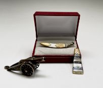 A Chinese silver miniature model of a canon, a silver and gold kukri brooch and a gold-mounted