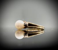 A pretty 14ct ring, set a pearl with two tiny diamonds. Marked 585. UK Postage: £15.04