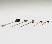 A gold nugget stick pin with 18ct gold pin sheath 6.1gm together with three other gold stick pins