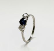 A three stone platinum ring set with a central sapphire and two diamonds. 2.8g.Ring size W1/2- X.