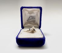 A 10ct gold dress ring set with two pearls and two small intense blue stones, possibly tanzanite.