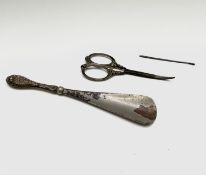 A silver handled shoe horn, London 1912, with a pair of silver handled toilet case scissors,