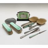 A silver and green enamel dressing table set - nine pieces, comprising of four brushes, a hand