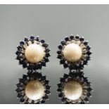 A pair of 18ct white gold earrings each with a pearl of 8.5mm within bands of diamonds and sapphires