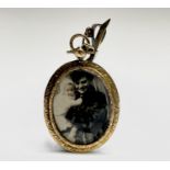 A Victorian high purity gold double-sided locket with chased decoration hanging from a swivel