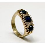 An 18ct gold Victorian style ring set with three graduated sapphires separated by trios of