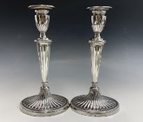 A pair of Adam style silver candlesticks by Charles Stuart Harris junior London 1891, each has