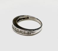 An 18ct white gold ring with a line of twelve calibre set diamonds. 4.6gm Condition: Signs of wear