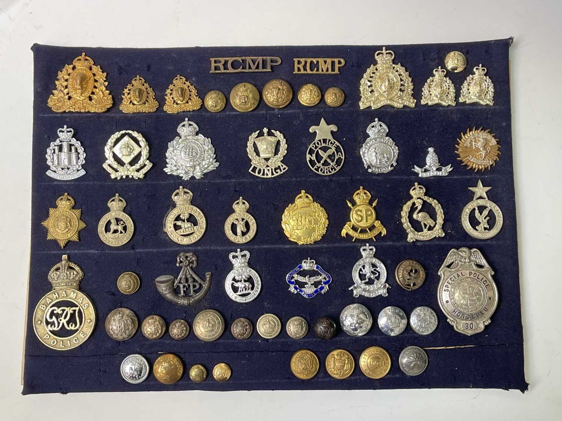 Police Forces - Foreign. A display card of Badges, Buttons and Shoulder Titles. Noted: Tonga Police,