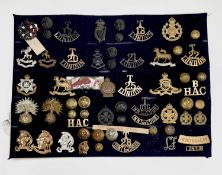 London Regiments - 1, Artists Rifles, etc. A display card containing cap badges, collar dogs,