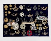 London Regiments - 2. A display card containing cap badges, collar dogs, shoulder titles and