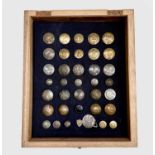 Livery Buttons (x36). Comprising a board mounted framed and glazed display of 36 brass and plated