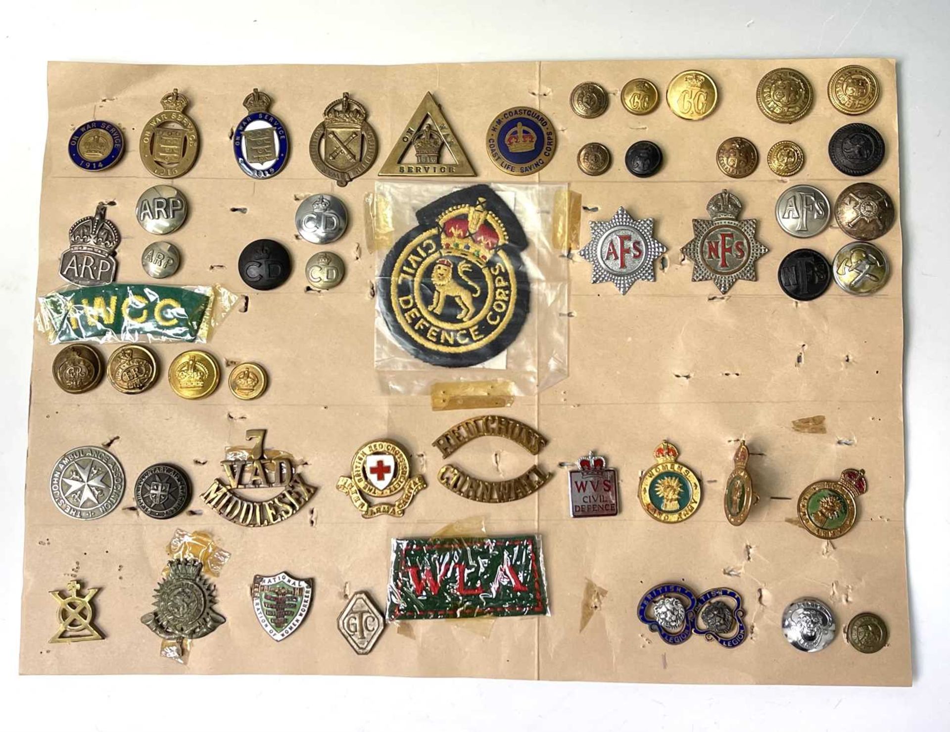 Military Auxiliary Services. A display card of badges, buttons, etc. Noted: On War Service, On War