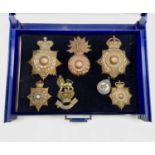 Royal Marines - 2. A blue plastic and glass display case containing 6 brass helmet badges, etc of