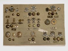 8th Hussars to 16th Lancers. A display card containing cap badges, collar dogs, shoulder titles