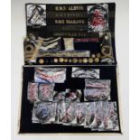 Royal Navy - 1. Two display cards containing various cloth shoulder titles, ship hat bands, buttons,