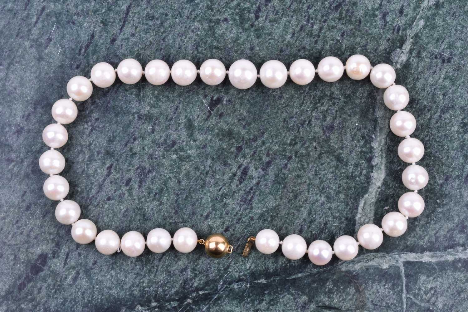 A freshwater pearl necklace, comprised of round white freshwater pearls, approximately 12-14 mm