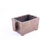 A Chinese bronze censer, of rectangular form, with two conforming handles, on short bracket feet,