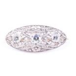 An Art Deco diamond and aquamarine brooch of elongated oval form, the openwork mount set with rose-