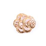 Kutchinsky. A yellow gold and diamond brooch, the overlapping textured mount scatter-set with