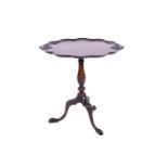 An early 20th century George III style mahogany tripod table, the shaped top with shell and scroll