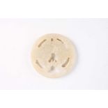 A Chinese jade amulet, Warring States period, of circular form, the centre with two conjoined