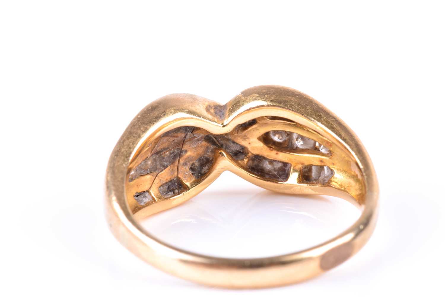 A yellow metal and diamond crossover ring, channel-set with mixed baguette-cut and round-cut - Image 4 of 4