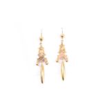 A pair of Victorian yellow gold drop earrings, with elongated drops beneath decorative mounts (