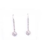 A pair of diamond drop earrings, set with round brilliant-cut diamond clusters beneath a vertical
