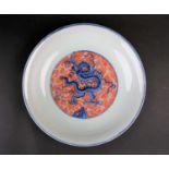 A Chinese dragon plate, of dished form, the centre painted with an Imperial dragon writhing