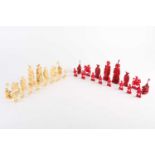 A Chinese natural and red stained ivory chess set, late 19th/early 20th century, the red king