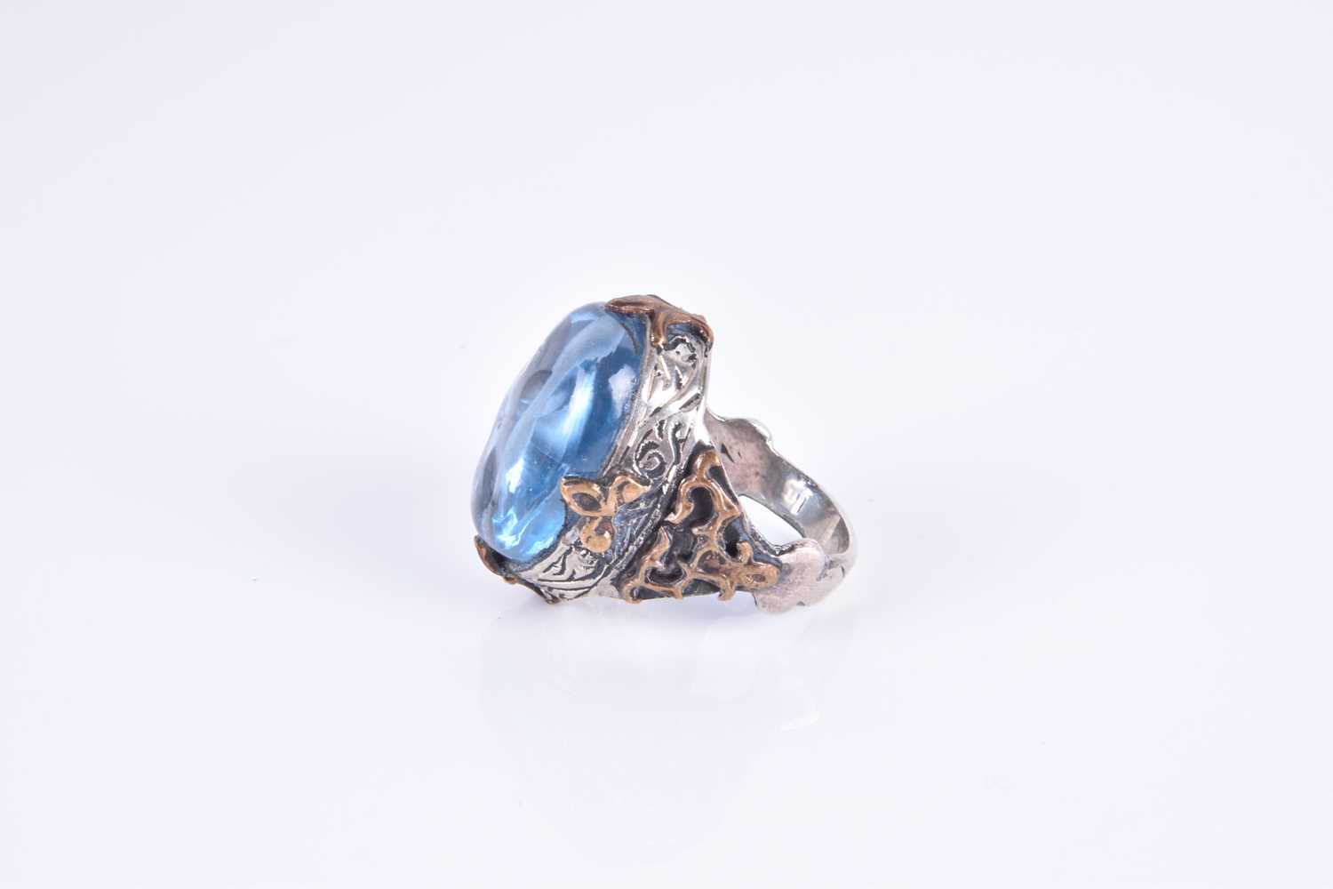 An unusual silver and blue glass ring,set with an oval blue glass cabochon, of stylised naturalistic - Image 2 of 3