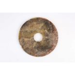 A large Chinese jade Bi disc, Western Han dynasty, the stone a mix of green and brown, of typical