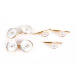 A pair of mother of pearl dress cufflinks and button studs, with diamond set centres, on gold