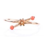 A late 19th / early 20th century yellow metal and coral bracelet, of crossover design, centred