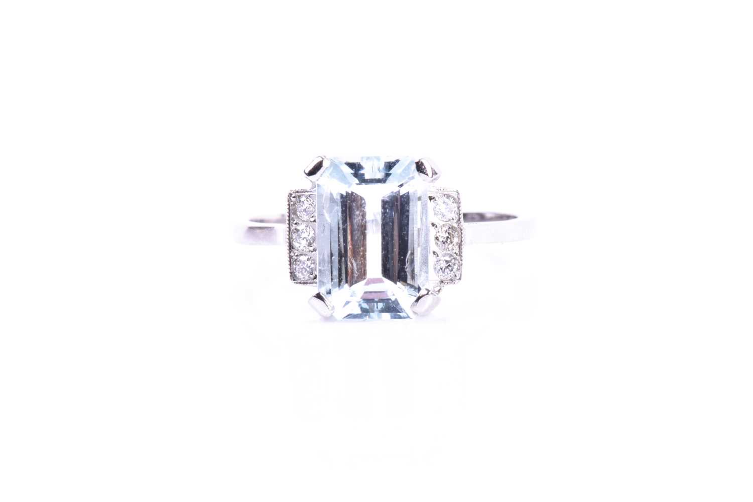 A platinum, diamond, and aquamarine ring, set with an emerald-cut aquamarine of approximately 2.55