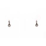 A pair of diamond drop earrings, the articulated mounts claw-set with a smaller and larger