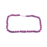 A ruby bead necklace, comprised of graduated faceted corundum beads, approximately 44 cm long,